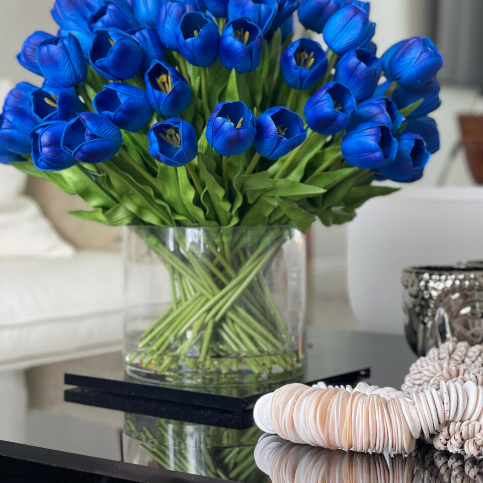 Arrangement of blue tulips in a large cylindrical vase